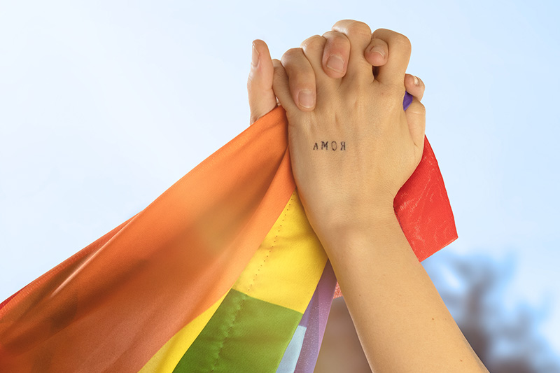 hands of two girls holding each other with the word love in the
